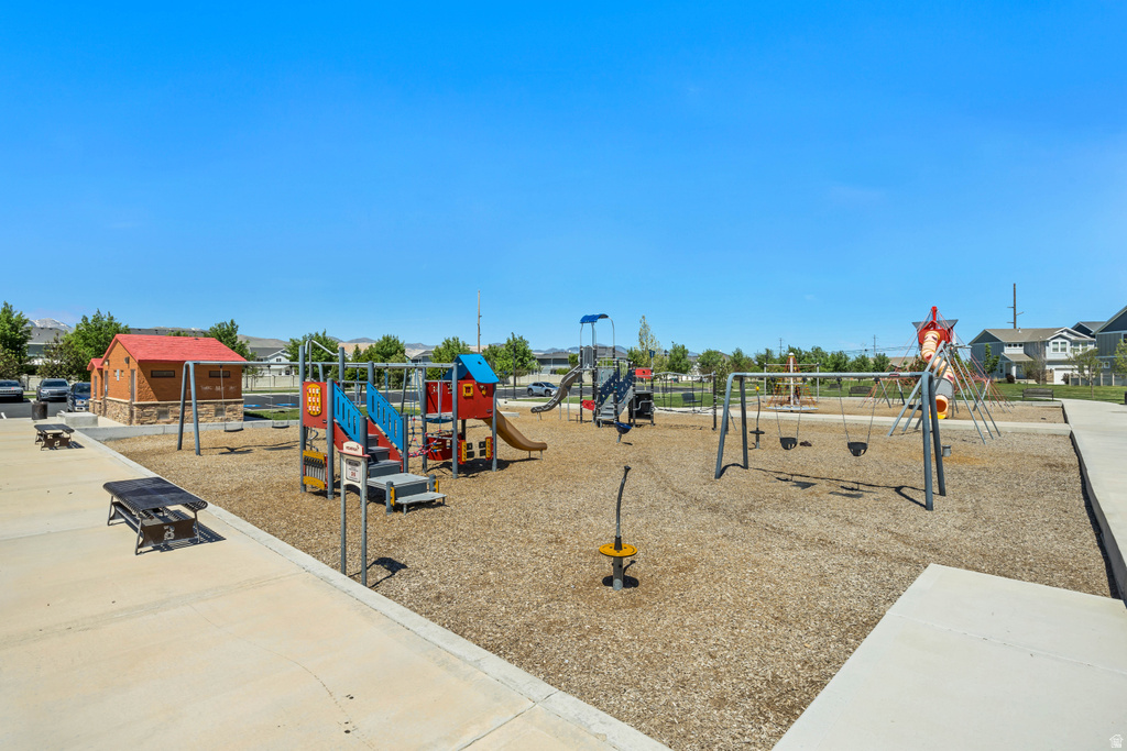 Outdoor play area featuring multiple structures, a swing set, slides, and wood chip ground cover