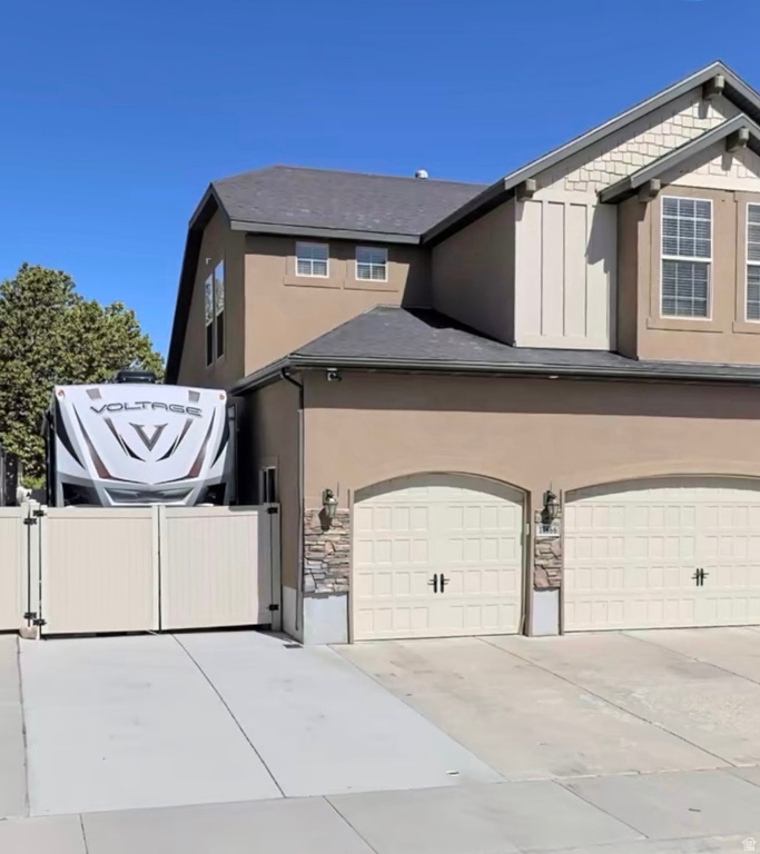 Stucco exterior residence with a two-car garage, a separate gated RV parking area, and an asphalt shingle roof