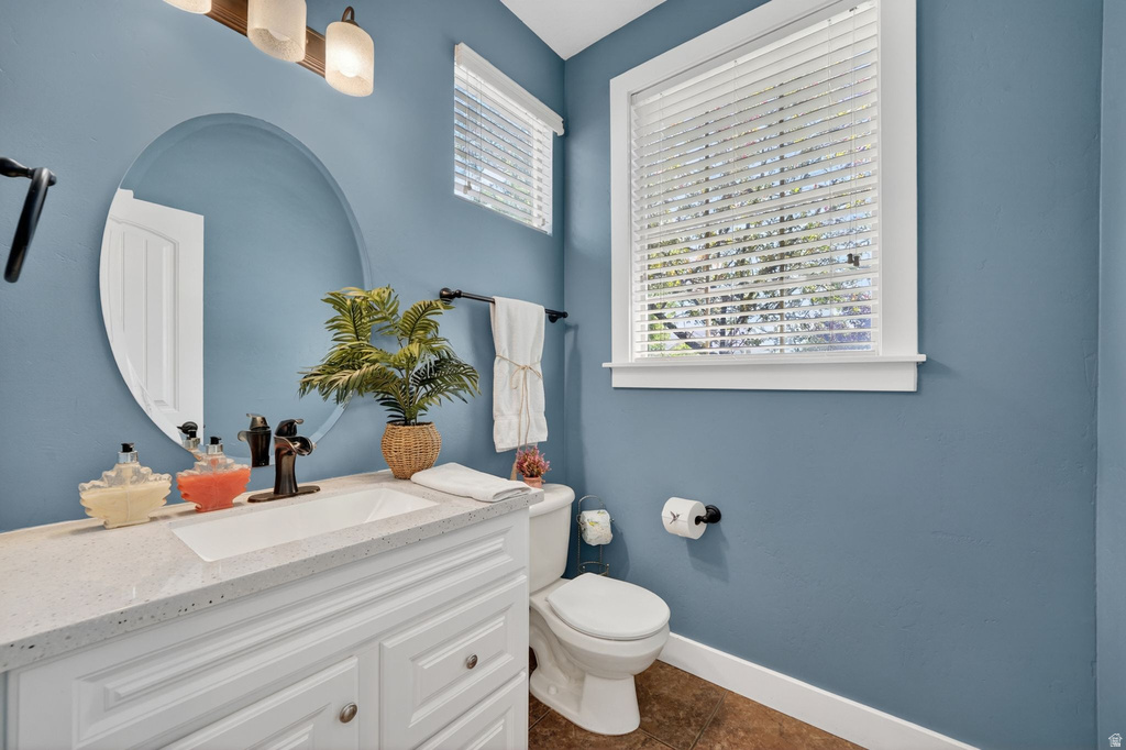 Bathroom vanity featuring a white rectangular sink with a bronze-finish faucet, framed by a large oval mirror