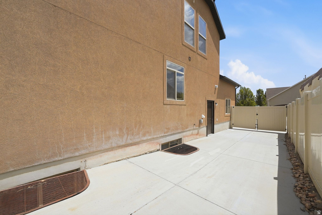 Paved concrete driveway with a privacy fence and a rear access gate