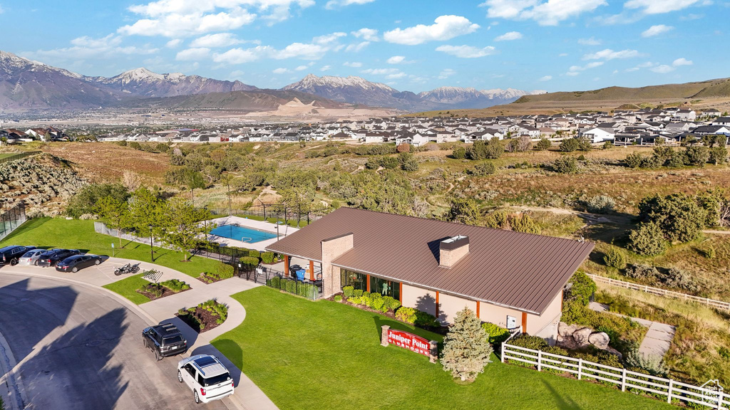 Community amenity building featuring a brown metal roof, stone accents, and an exterior swimming pool