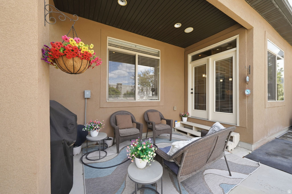 Covered patio featuring recessed lighting, a stucco exterior, double French doors, and multiple windows