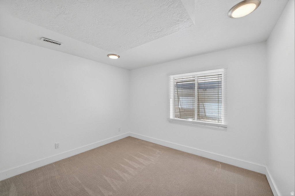Carpeted interior room featuring a window with horizontal blinds, recessed lighting, and white baseboards