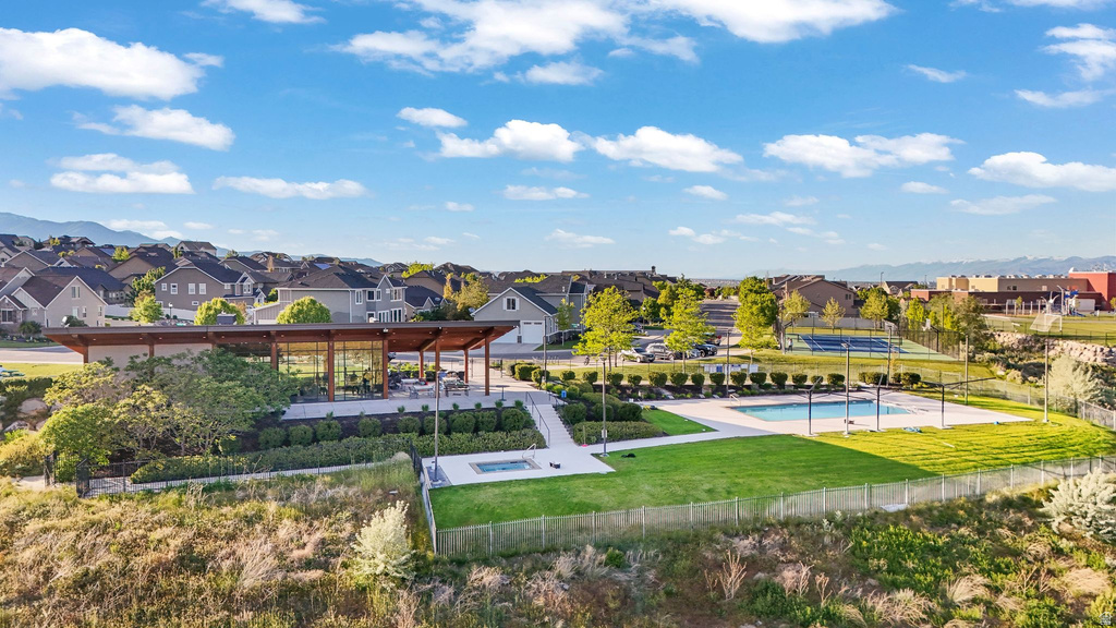Community amenities featuring a pavilion with outdoor seating, a swimming pool, a separate spa, and a tennis court, all surrounded by landscaped grounds
