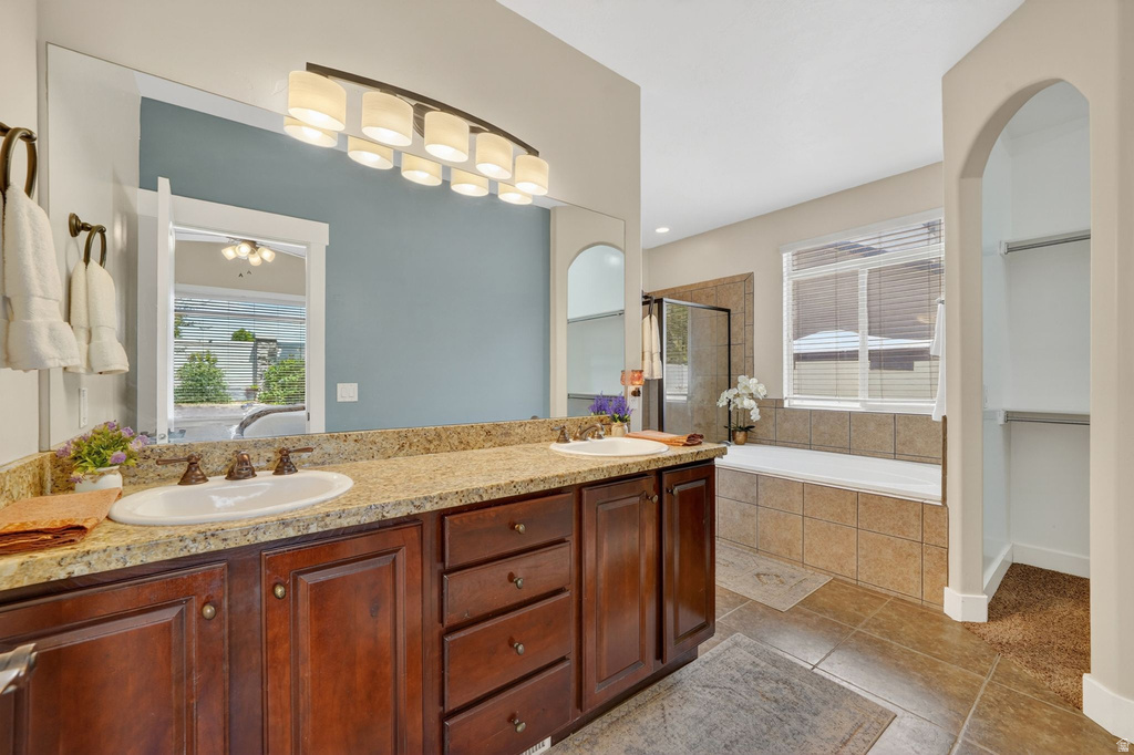 Dual vanity with undermount sinks, granite-look countertop, and dark wood cabinetry