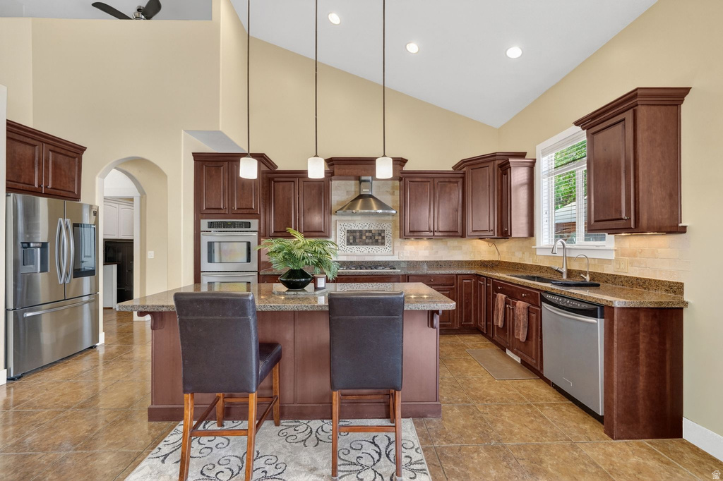 Open-concept kitchen featuring vaulted ceilings, recessed lighting, and a central island with pendant lights