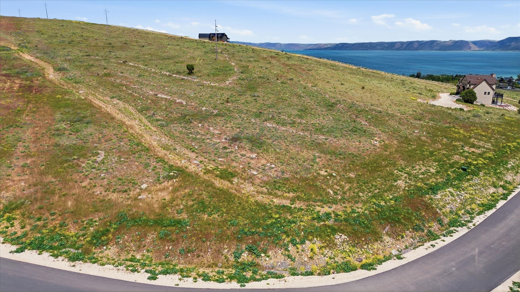 Sloping land with paved road frontage and distant water and mountains
