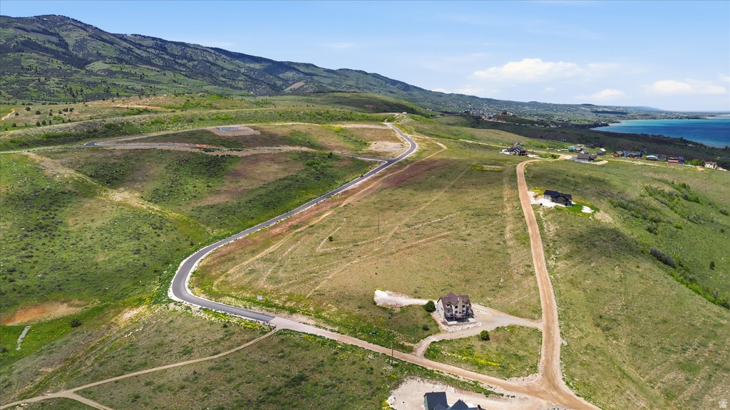 Acreage with a partially paved road and a neighboring residence