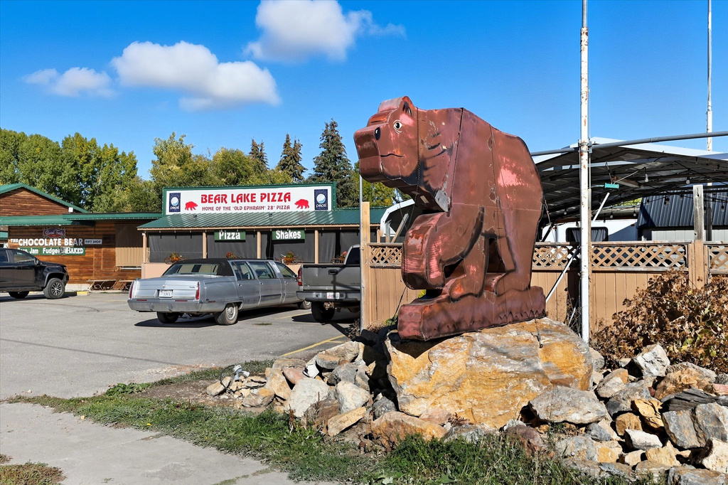 Paved parking area featuring a prominent bear sculpture on a stone base