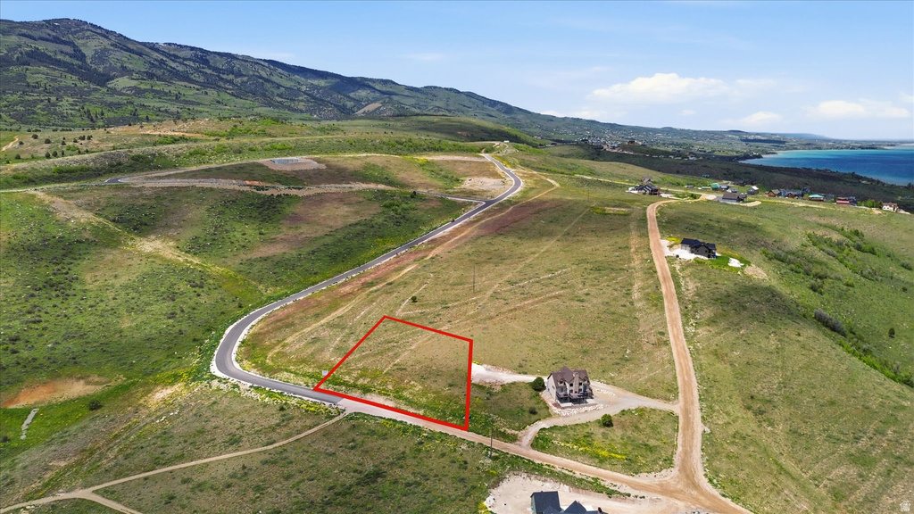 Expansive sloped lot featuring a paved road frontage
