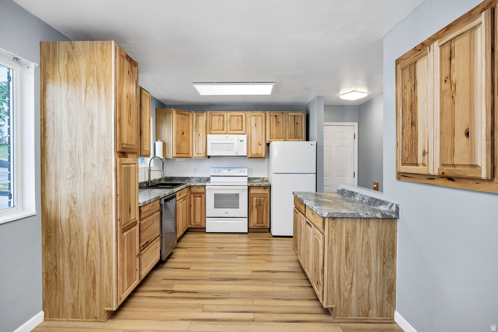 Kitchen featuring light wood-finish cabinetry, granite-style countertops, wood-finish flooring, white appliances, and recessed lighting