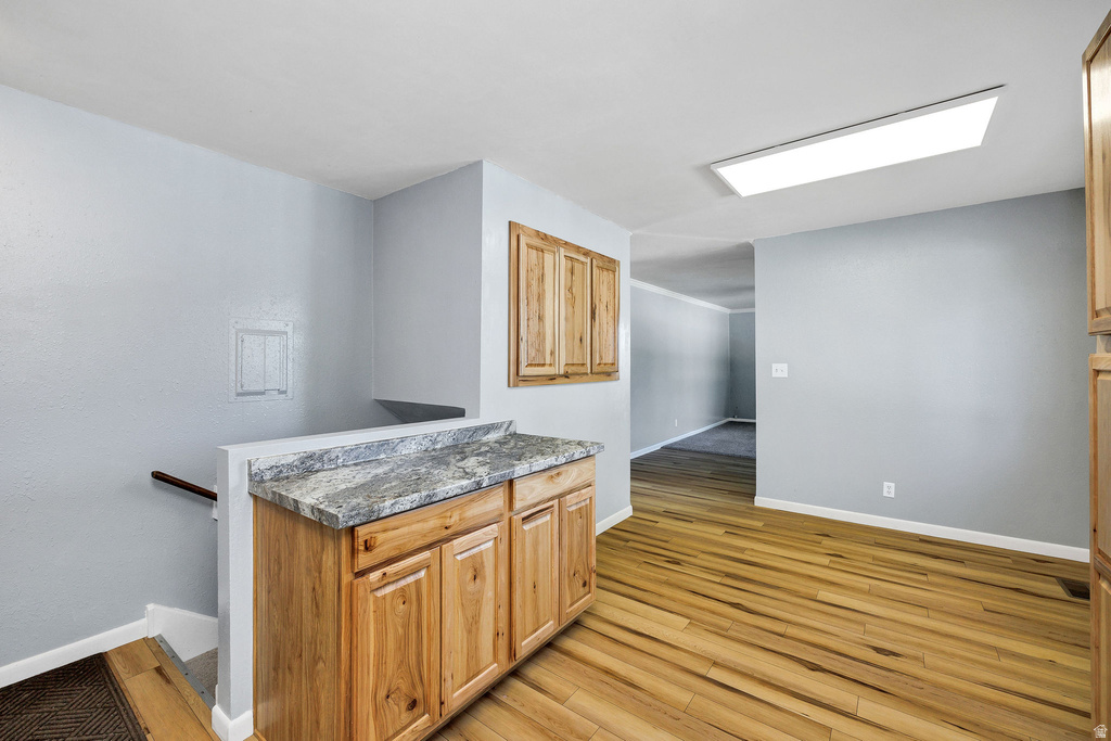 Wood-finish flooring throughout, featuring a built-in cabinet with a stone-finish countertop