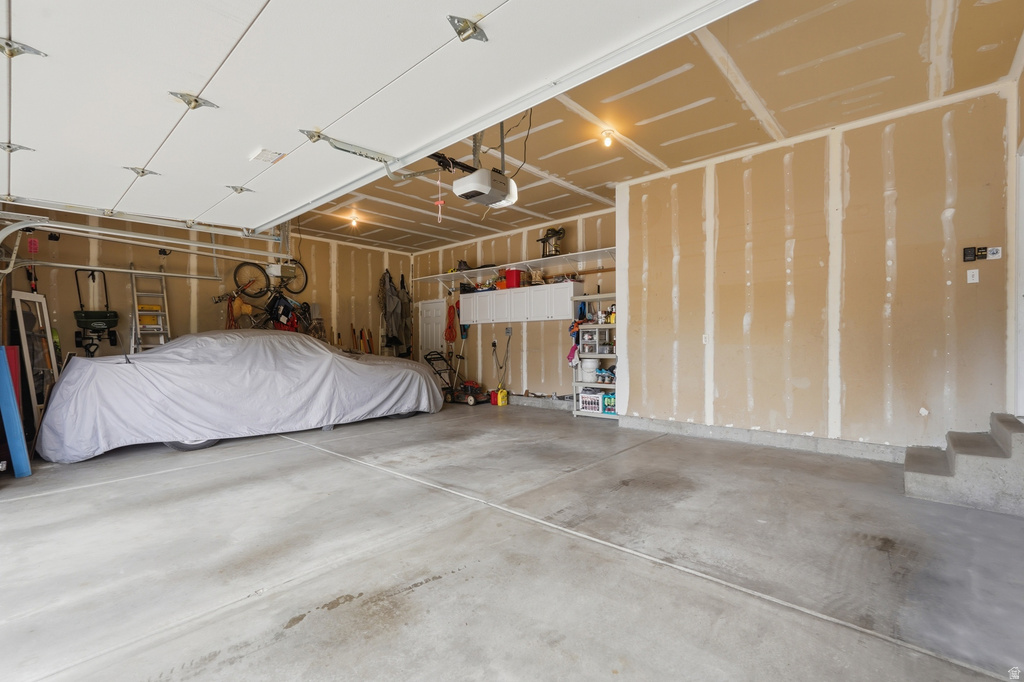 Spacious garage with concrete flooring, exposed wall studs, and ceiling-mounted lighting fixtures