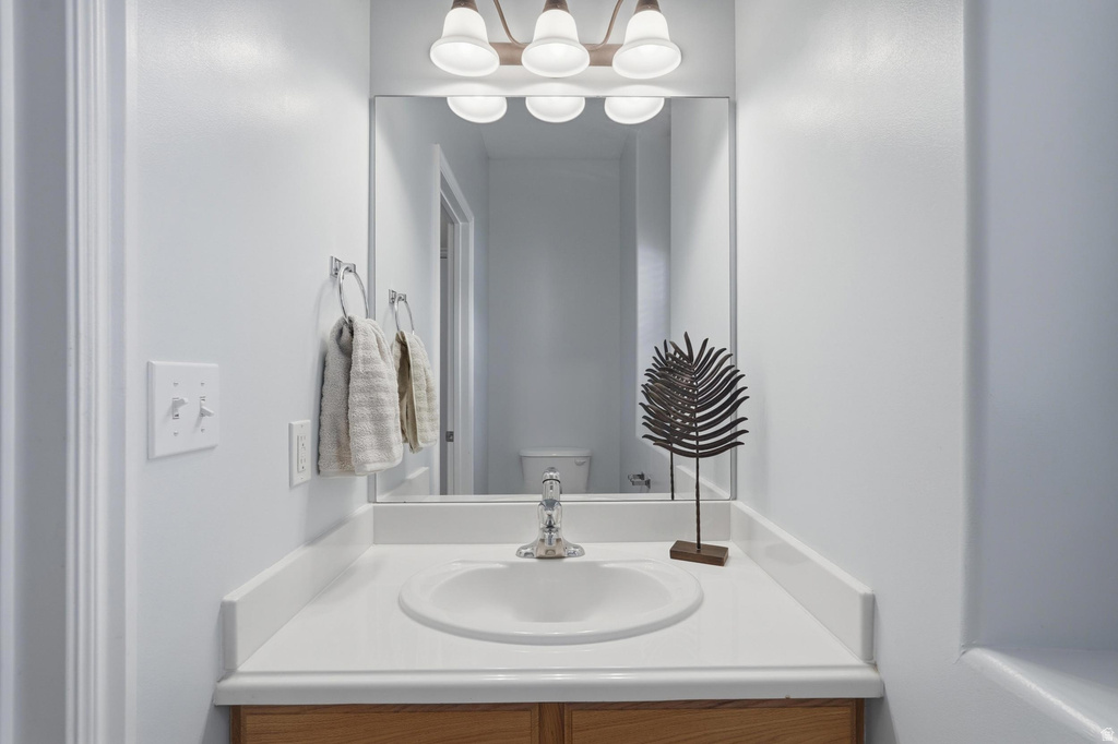 Bathroom vanity with an integrated sink, polished chrome faucet, and a large wall-mounted mirror