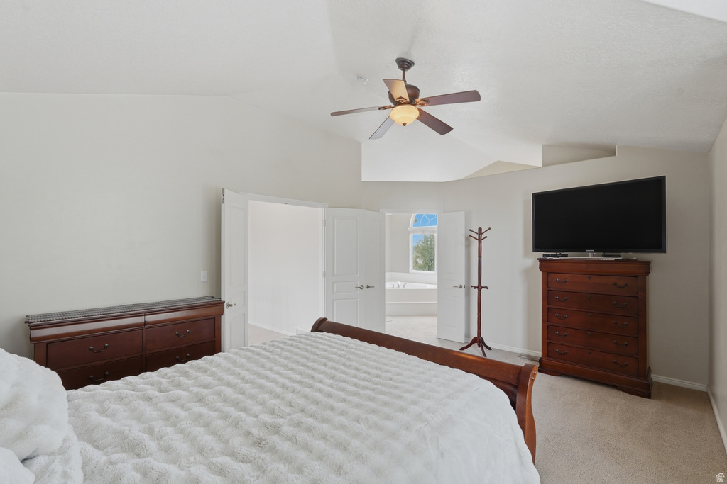 Spacious bedroom featuring vaulted ceilings, a ceiling fan with integrated lighting, and neutral wall tones