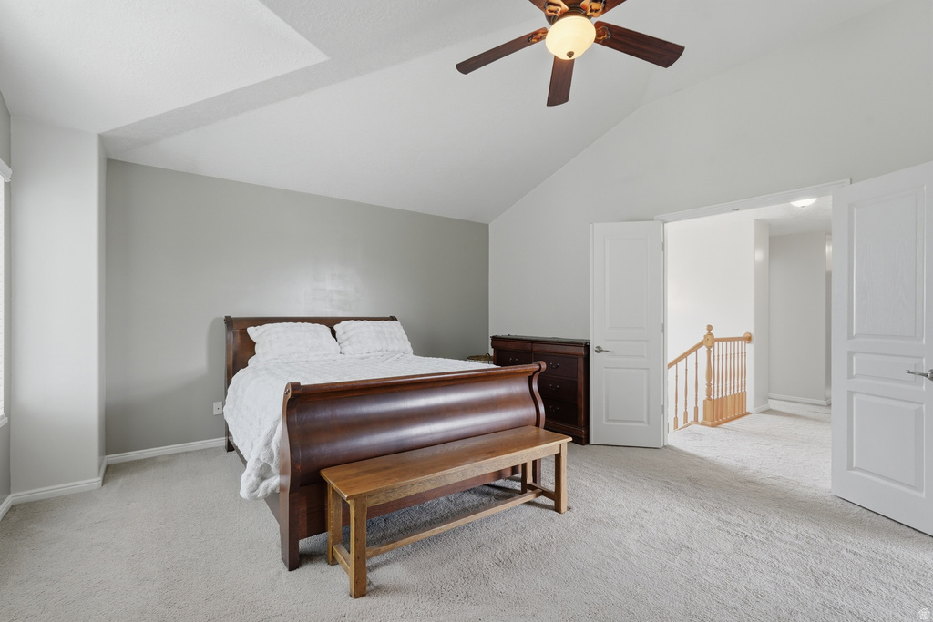 Spacious room featuring vaulted ceilings, a ceiling fan with integrated lighting, and light gray wall paint