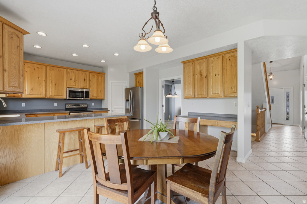 Kitchen and dining area featuring warm wood cabinetry, stainless steel appliances, and recessed lighting