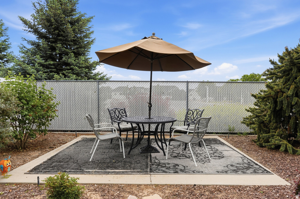 Outdoor patio area featuring a concrete slab with a decorative rug