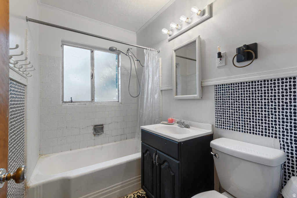 Bathroom featuring a white tub, window with frosted glass panes, black vanity with white sink, white toilet, and patterned tile accent wall