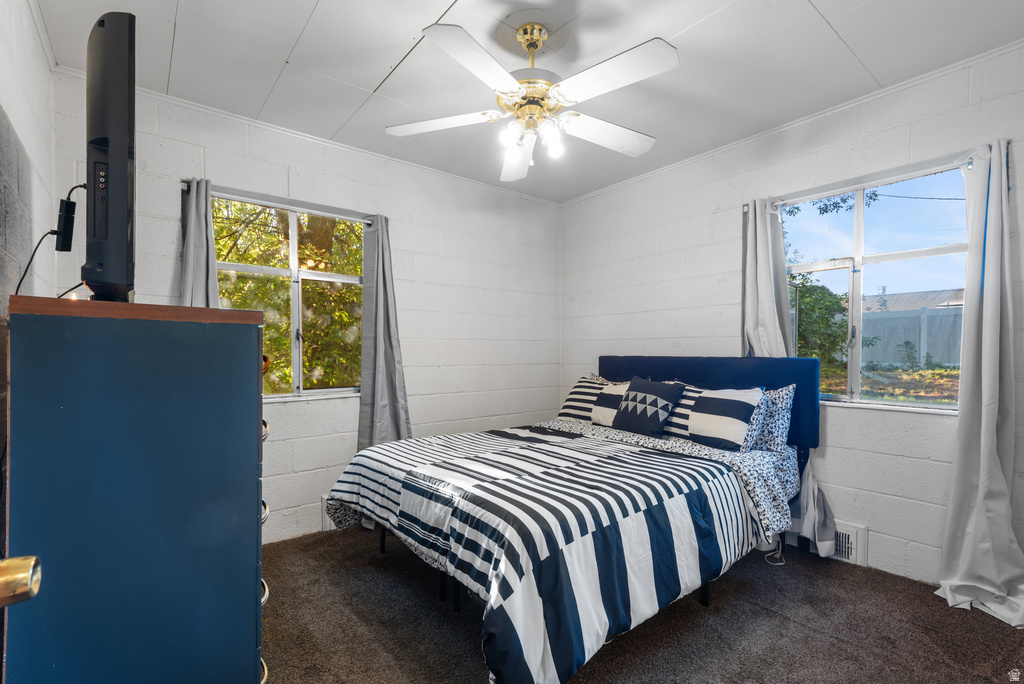 Room featuring two windows, a ceiling fan with integrated lighting, and carpet flooring