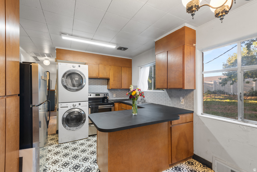 Kitchen featuring wood cabinetry, black countertops, hexagonal tile backsplash, and patterned flooring