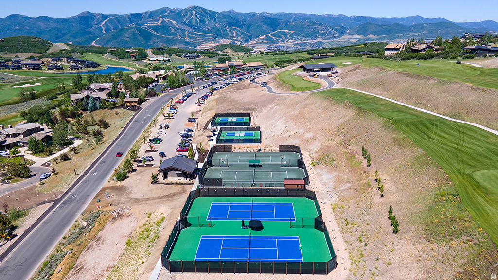 Outdoor recreational area featuring multiple tennis and pickleball courts with mountain scenery