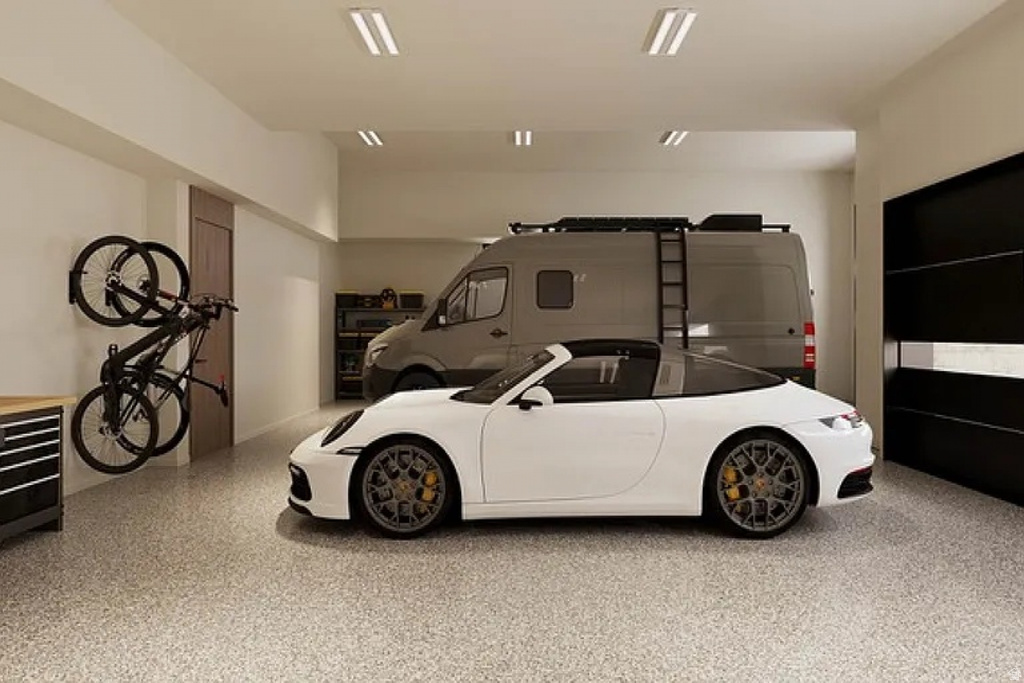 Spacious garage featuring a speckled epoxy floor finish and bright overhead lighting