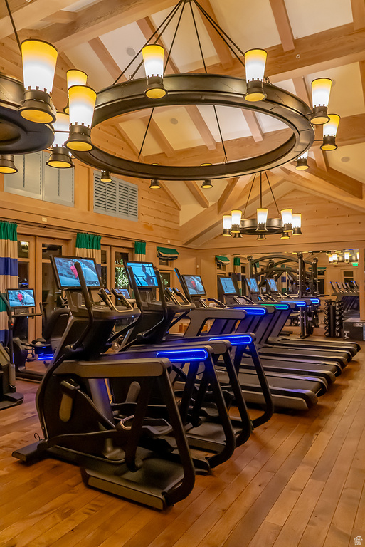 Fitness center with wood-finish flooring, vaulted wood-paneled ceilings, and exposed wood beams