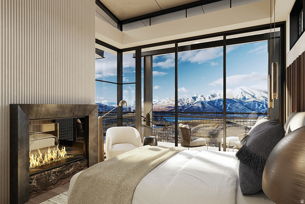 Floor-to-ceiling glass windows frame expansive mountain and water scenery