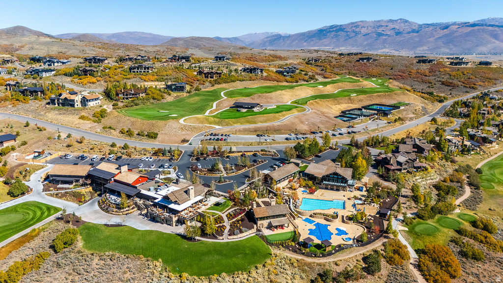 Expansive golf course community featuring multiple green spaces, a large outdoor pool, and a distinct clubhouse with extensive outdoor patio areas