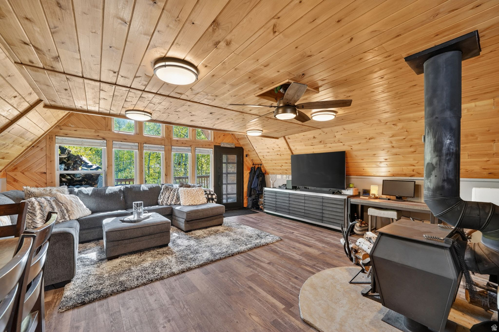 Open-concept living area featuring wood-finish flooring and sloped wood-paneled ceilings