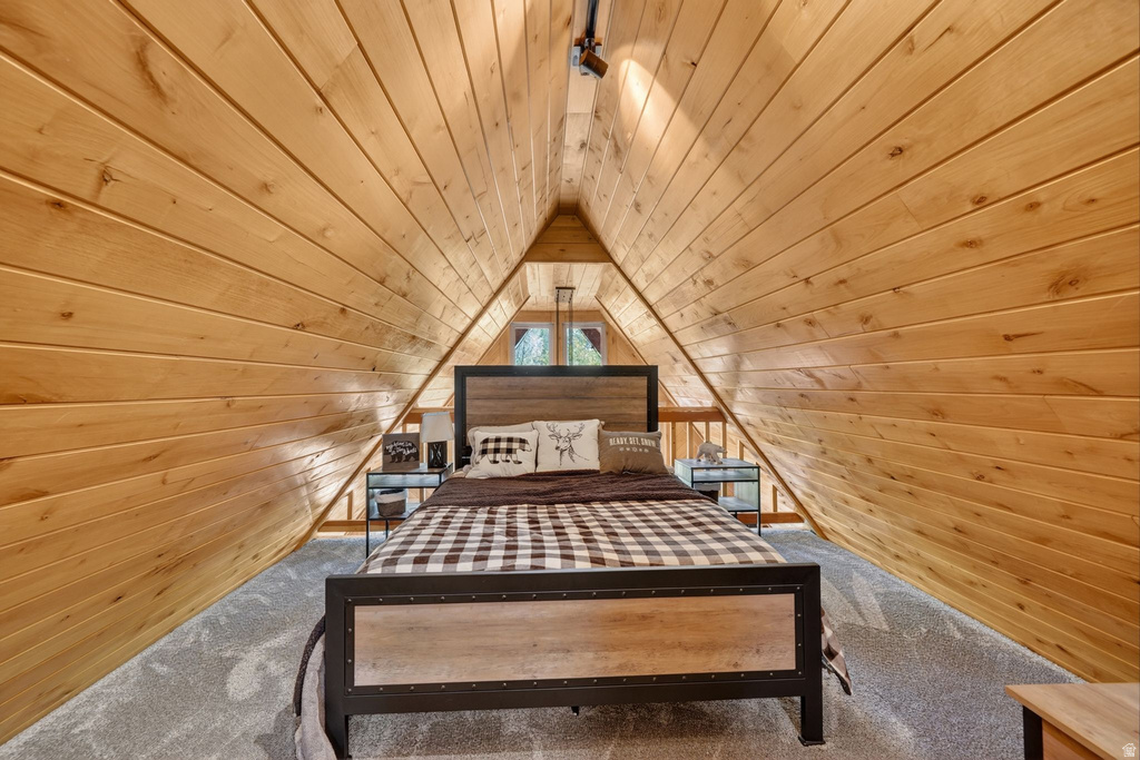 Vaulted wood-paneled ceiling with track lighting, complementing wood-finish side tables, and a visible window with natural light