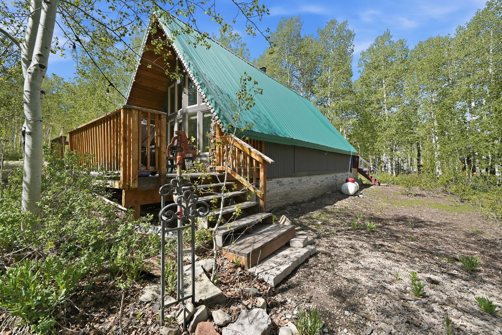A-frame exterior with a green corrugated metal roof and wood siding