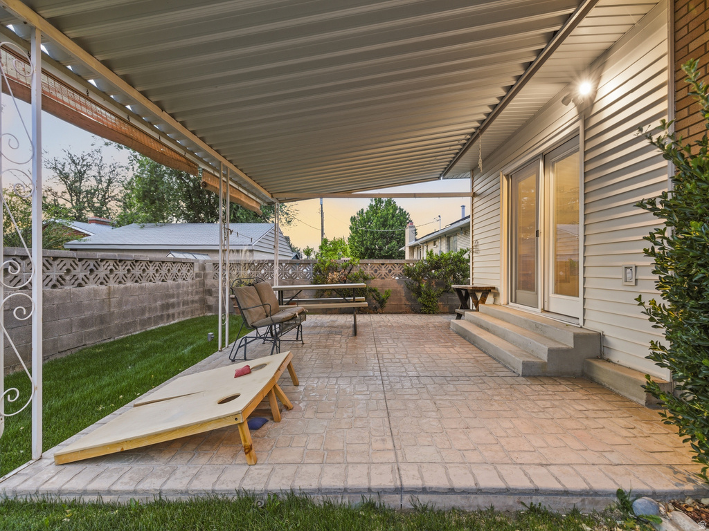 Covered patio with stamped concrete flooring, supported by decorative metal columns