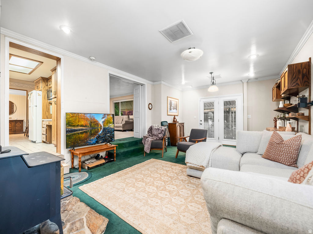 Living area featuring recessed lighting, green carpeting, and a stone hearth with a dark-finished stove