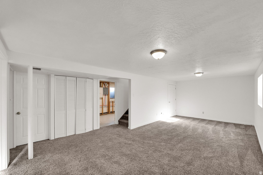 Spacious room with gray carpet, white walls, and flush-mount ceiling lights