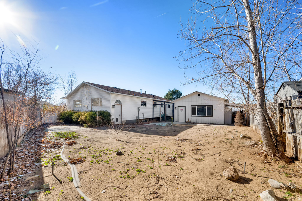 Expansive backyard featuring a detached structure, perimeter fencing, and mature trees
