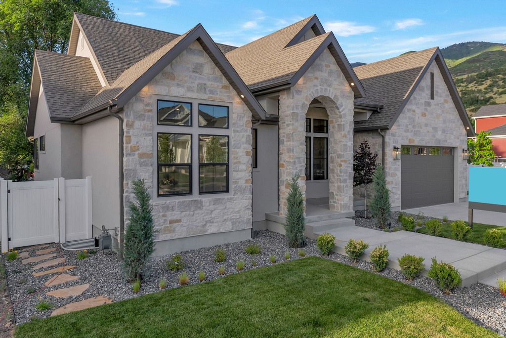 Stone and stucco exterior featuring a prominent arched entryway