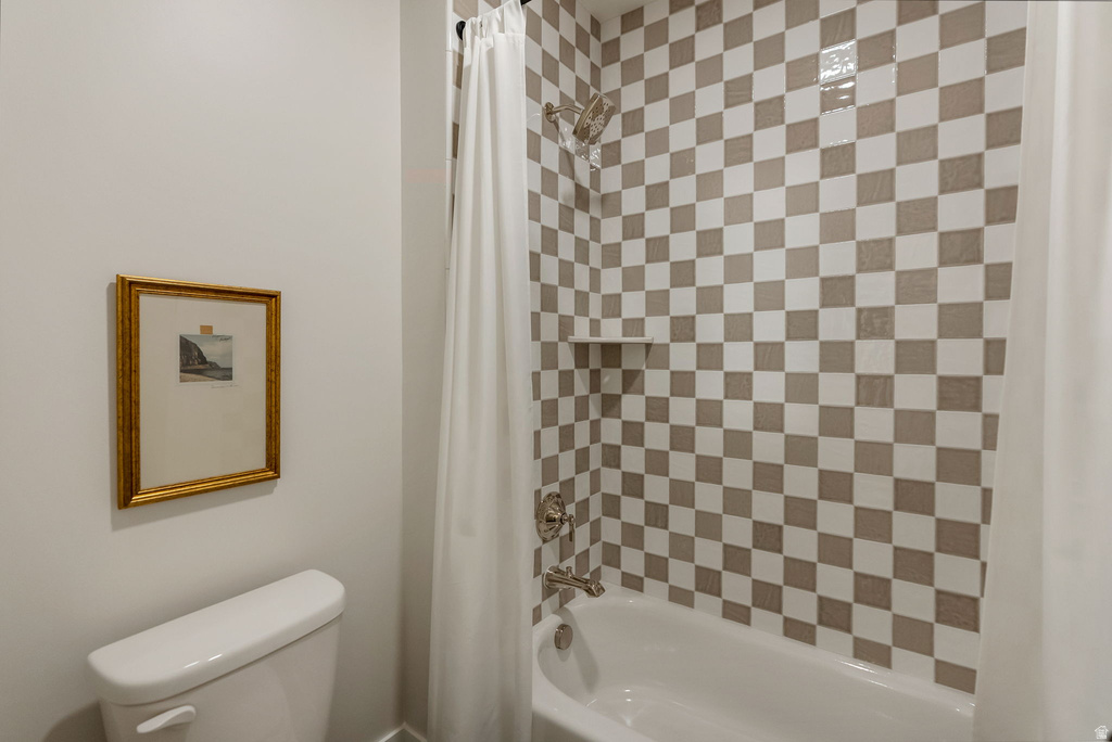 Bathroom featuring a white bathtub, checkered wall tiling, and an integrated shower niche