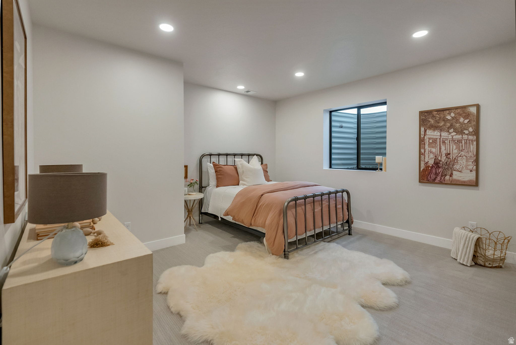 Carpeted room featuring recessed lighting, a window with a well-style enclosure, and light-toned walls