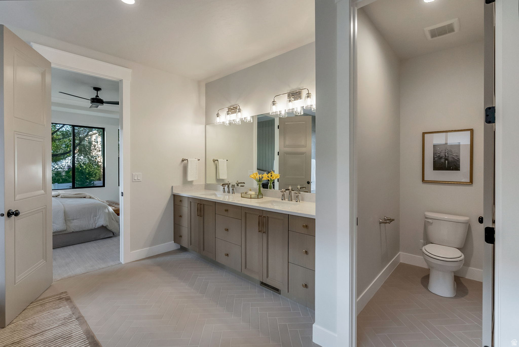 Bathroom featuring a double vanity with stone countertops and two rectangular undermount sinks, illuminated by two wall-mounted light fixtures