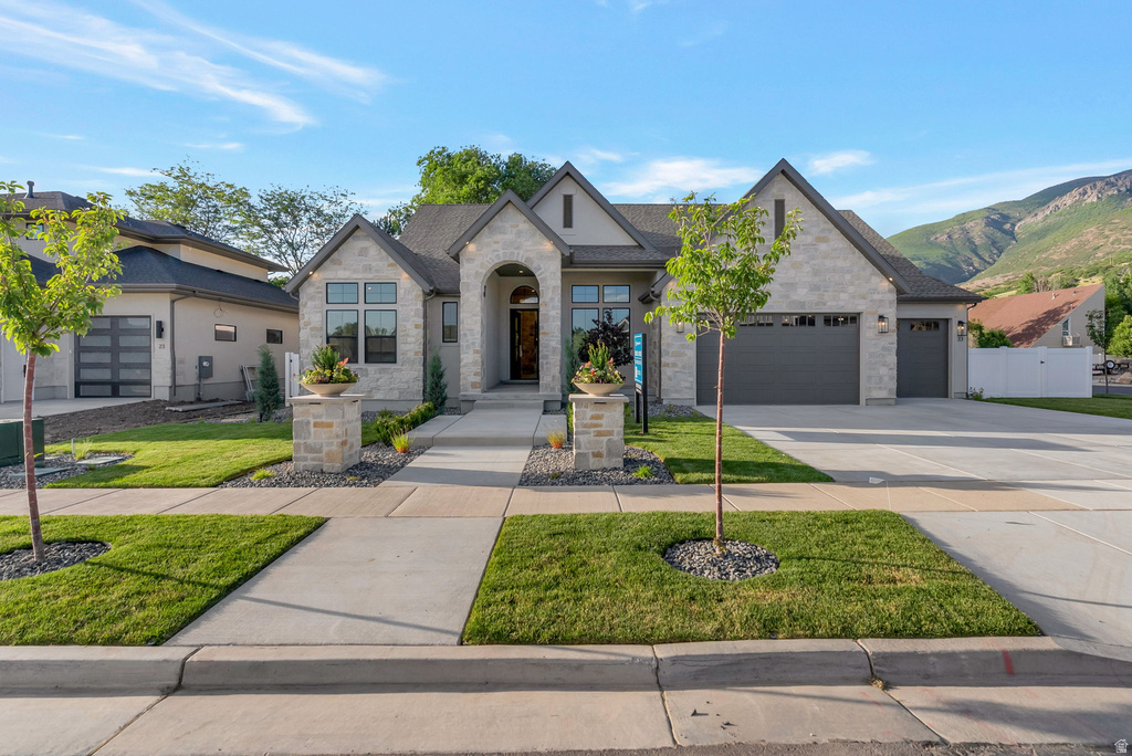 Contemporary stone and stucco exterior with multiple gables