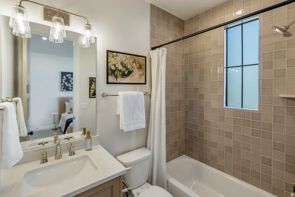 Bathroom featuring a single vanity with an undermount sink, brushed nickel faucet, and integrated countertop