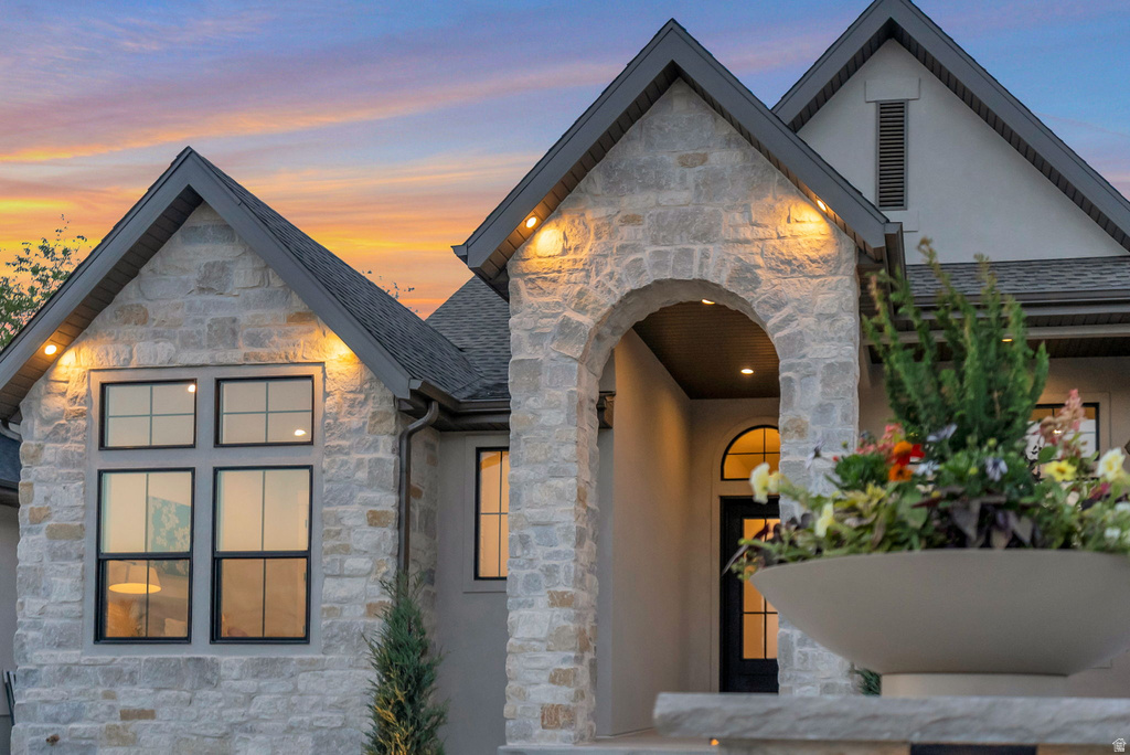 Stone and stucco facade featuring multiple gables and dark-framed windows