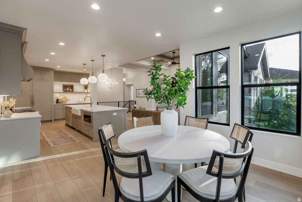 Open concept kitchen and dining area featuring light wood-finish flooring, recessed lighting, and large black-framed windows