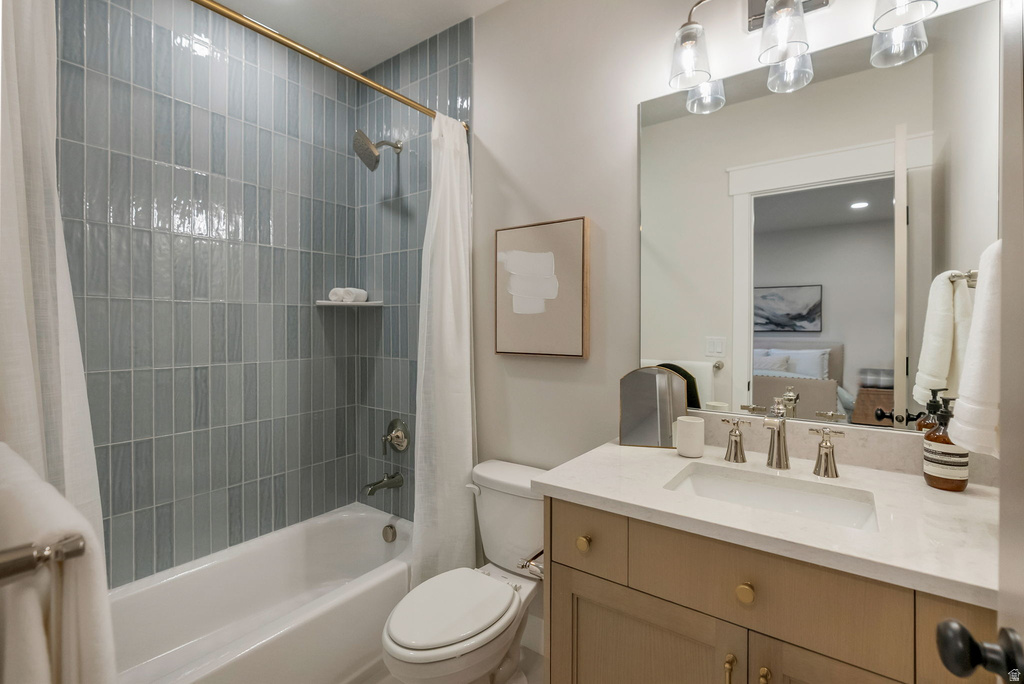 Bathroom featuring a full tub/shower combination with vertical tile surround, a built-in shower niche, and a gold-finish shower rod