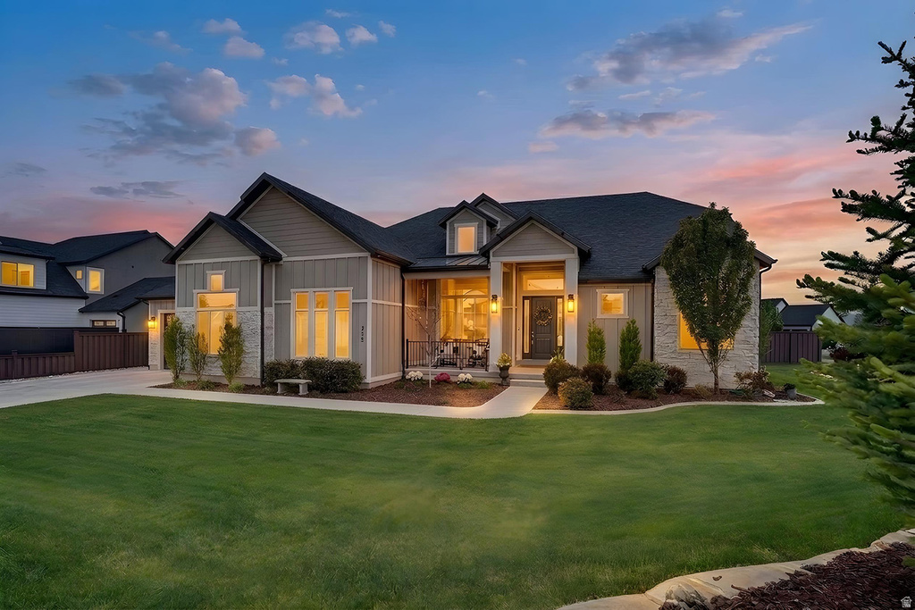 Contemporary residence featuring a prominent gabled roofline and a combination of horizontal siding and stone veneer