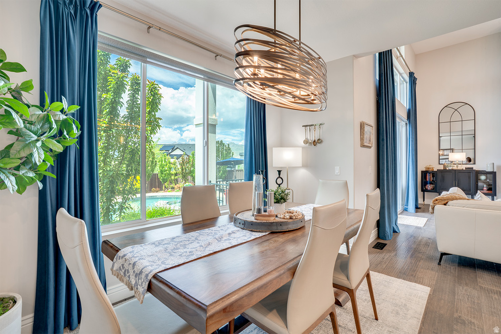 Dining area featuring a dark wood table with a detailed runner, complemented by a unique sculptural chandelier