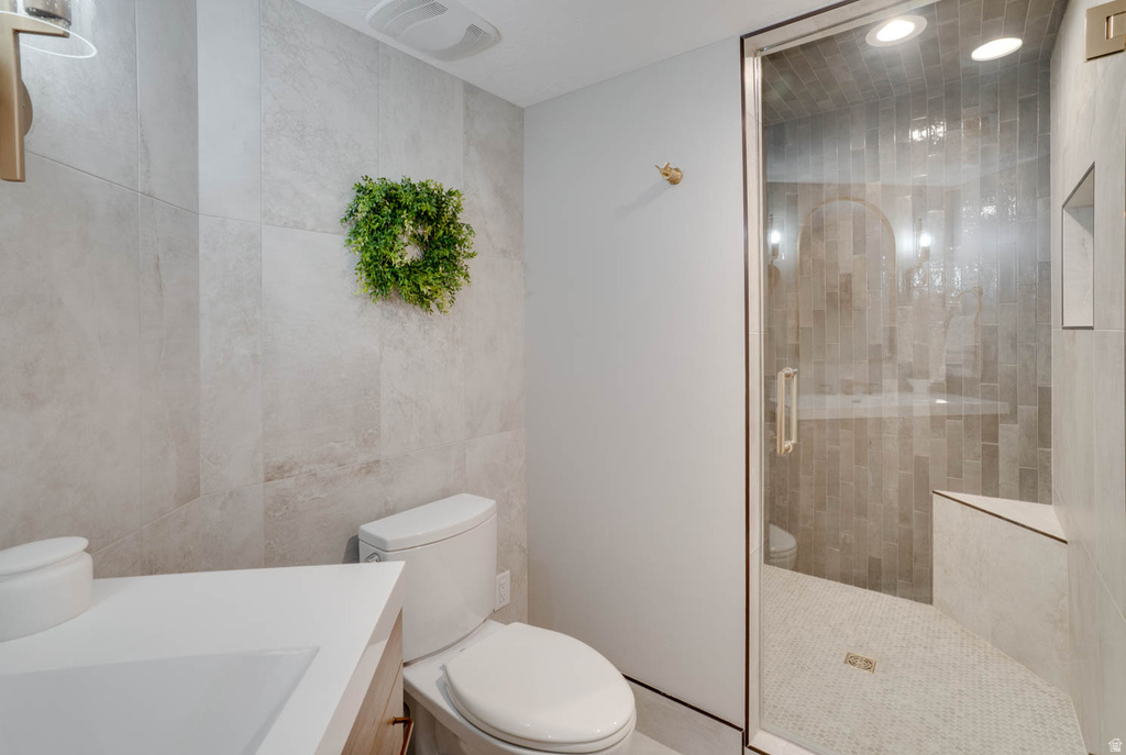 Full bathroom featuring a frameless glass shower enclosure, a built-in shower bench, and a vertical tile shower surround