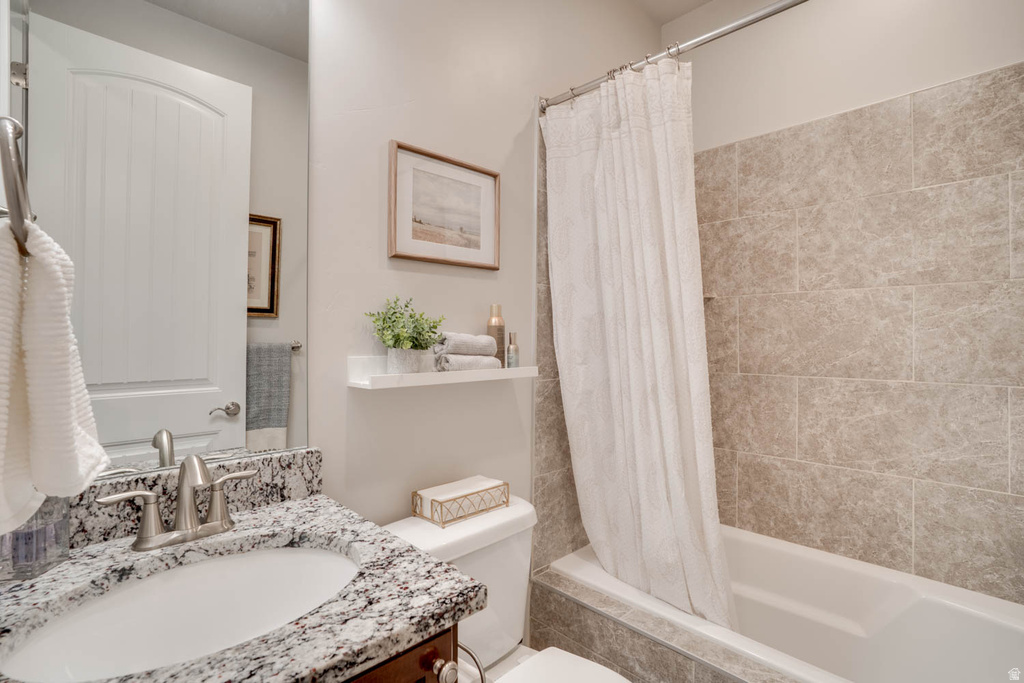 Bathroom featuring a single vanity with a patterned countertop, undermount sink, and brushed nickel faucet